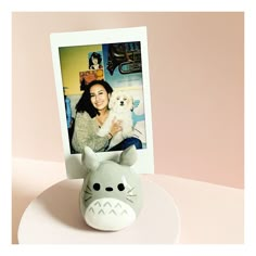 a photo frame with an image of a woman holding a dog and a totoro figurine