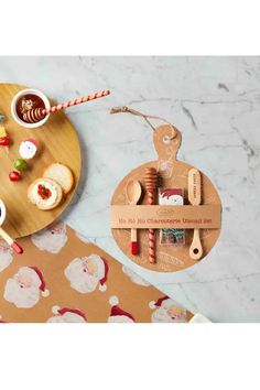 two wooden spoons and plates with food on them sitting on a marble table top