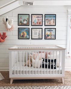 a white crib with posters on the wall