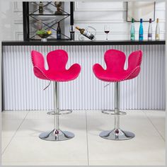 two pink chairs sitting on top of a white tile floor next to a bar counter