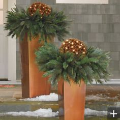 two tall planters with christmas decorations on them