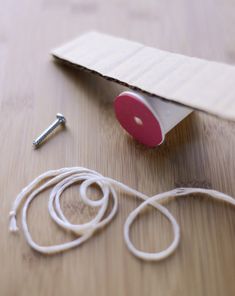 a piece of paper and some wires on a wooden table next to a pair of scissors