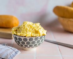 a bowl filled with scrambled eggs on top of a table