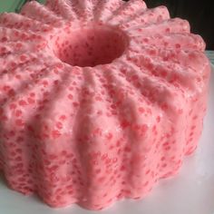 a pink cake sitting on top of a white plate