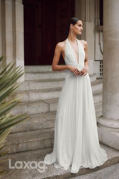 a woman in a white dress standing on some steps