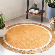 a round rug on the floor next to some potted plants