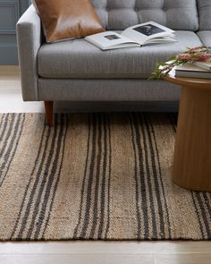 a living room with a couch, coffee table and rug on the floor in front of it