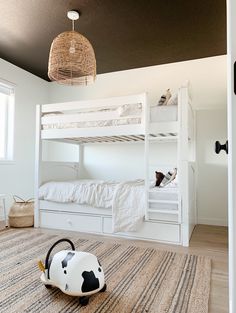 a bedroom with bunk beds and a cow toy on the floor in front of it