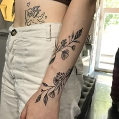 two people with tattoos on their arms and one is holding the other's hand