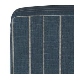 the blue and white striped ottoman is upholstered with ticking lines on it's sides