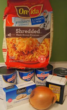 some food is sitting on top of a counter next to cans and spoons with one bag of shredded cheese in it