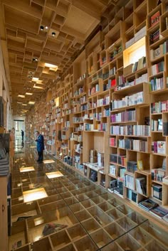 a man standing in front of a bookshelf filled with lots of book's