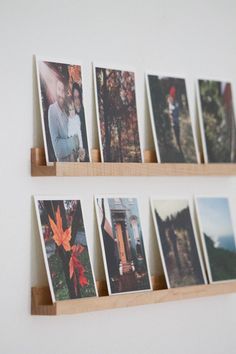 several photos are hanging on the wall with wooden shelves holding them in front of each other