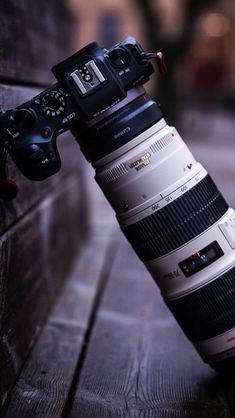 a camera mounted on the side of a wall with a lens attached to it's body