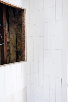 an unfinished bathroom with white walls and tile