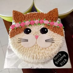 there is a cake that looks like a cat with flowers on its head and ears