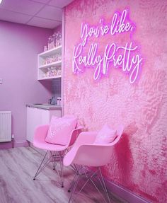 two pink chairs in front of a wall that says you're like really pretty