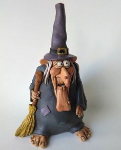 a figurine of an evil wizard holding a broom and wearing a purple hat