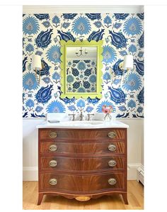 a bathroom vanity with blue and white wallpaper