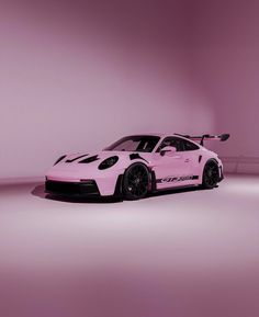 a pink sports car parked in a dimly lit room