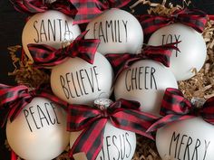 christmas ornaments with the words santa, family, and cheer written on them in black and red ribbon