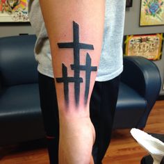 a person with a cross tattoo on their arm