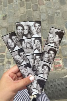 a person holding up several photos of people in front of a brick wall and sidewalk