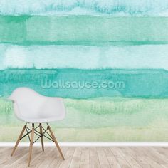 a chair sitting in front of a wall with green and blue watercolor paint on it