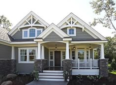 a gray house with white trim and two story front porches on the first floor