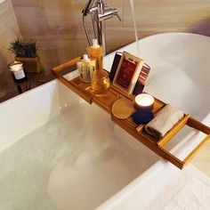 a bathtub with candles, soap and books on it