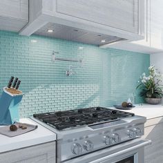 a stove top oven sitting inside of a kitchen next to a counter with utensils on it