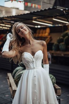 a woman in a white dress is posing for the camera