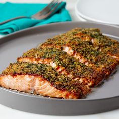 two pieces of salmon on a plate with seasoning