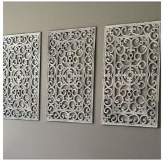 three white metal wall panels mounted to the side of a wall in a living room