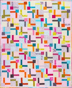 a quilt made with blocks and squares in pink, blue, yellow, green, orange