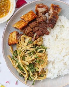 a plate with rice, meat and vegetables on it