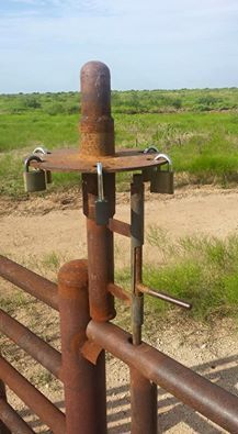 an old rusted metal fence in the middle of nowhere