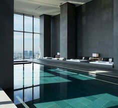 an indoor swimming pool with large windows overlooking the city