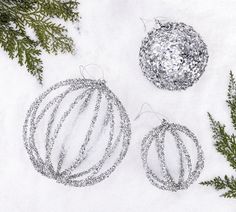 three christmas ornaments are shown in the snow