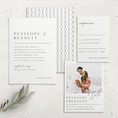 the wedding stationery is laid out on a white surface with greenery and an olive branch