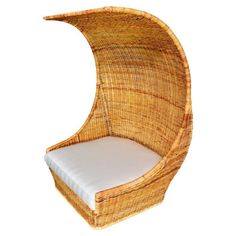 a chair made out of wicker with a white cushion