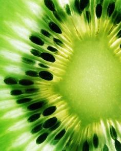 the inside of a kiwi fruit with black dots on it's green center