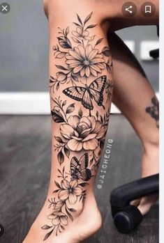 a woman's leg with flowers and butterflies on it