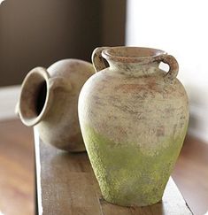 two vases sitting on top of a wooden table