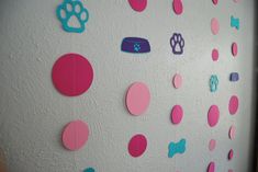 the wall is decorated with pink, blue and green polka dot paper cutout shapes