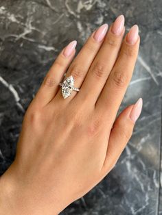 a woman's hand with a diamond ring on it