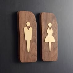 two wooden magnets that have people in the shape of men and women on them