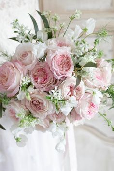 a bride holding a bouquet of pink and white flowers