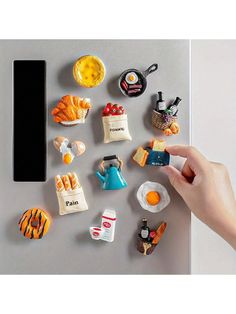 a hand is pointing at miniature food items