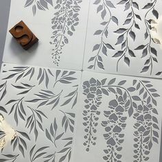 the stencils are being used to cut out paper flowers and leaves for wall art